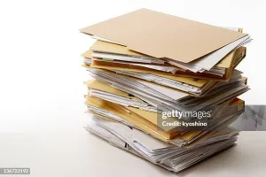 Stacked brown file folders isolated on white with soft shadow.