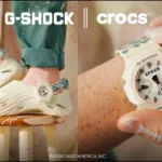 La collaborazione tra G-SHOCK e Crocs debutta con una versione esclusiva delle Crocs Echo Wave, caratterizzata da una tomaia color crema con finitura glow-in-the-dark. Il dettaglio che cattura subito l’occhio è il cinturino alla caviglia, realizzato in una particolare marmorizzazione verde e rosa, ispirata alla robustezza e allo stile inconfondibile dei G-SHOCK.