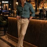 Questo look funziona perché unisce comfort e struttura. La camicia verde petrolio aggiunge profondità. Il pantalone sabbia mantiene equilibrio e pulizia visiva.